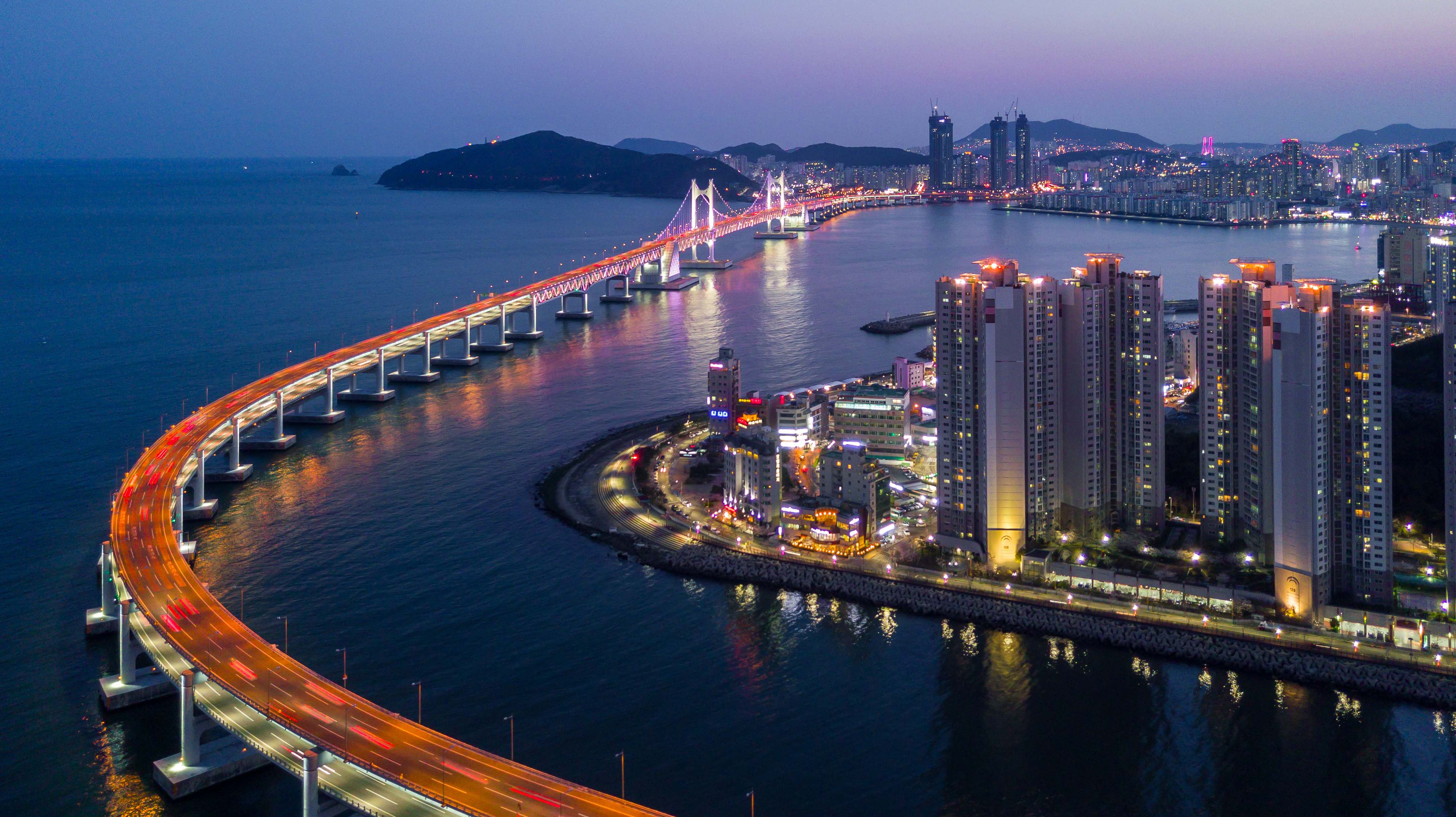 Gwangan Bridge curving across the bay in Busan at twilight